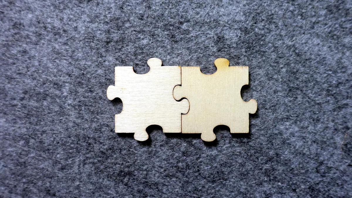 Two puzzle pieces from different sets pressed together, the edges matching almost but not quite.