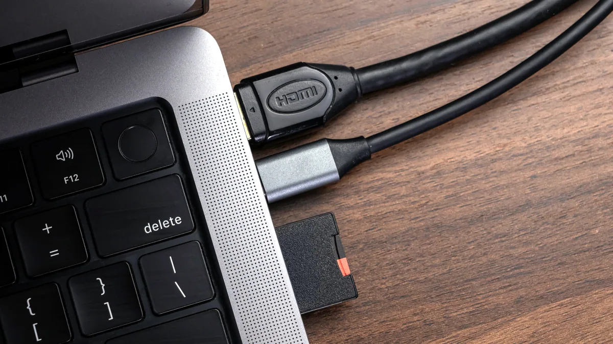 A short USB cable plugged into a small power adapter, the cord resting on a desk edge.